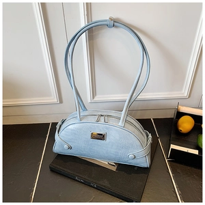 Close-up of light blue crocodile texture handbag with silver metal logo plaque detail