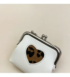 Detail of white PU leather mini bag with leopard heart cutout and silver kiss-lock