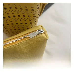 Gros plan détaillé du sac seau jaune ajouré avec fermeture éclair en métal argenté