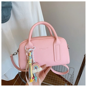 Pink litchi grain leather pillow bag detail with FASHION & BAGS text and rainbow tassel