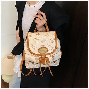 Detail view of cream bucket bag featuring bear patterns and brown leather trim