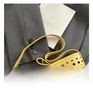 Détail du sac seau jaune ajouré avec texture grainée et découpes géométriques chic