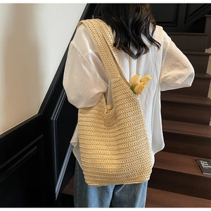 Detailed view of handmade woven straw tote bag featuring wide shoulder strap and spacious design