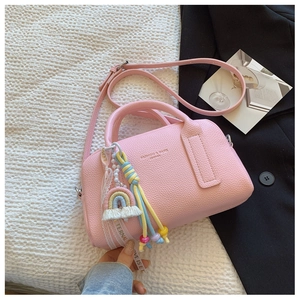 Detail of pink lychee leather handbag with rainbow tassels and stylish pearl charms