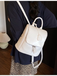 Modern white glossy PU leather backpack for women shown in a stylish indoor setting