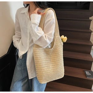 Detailed close-up of woven beige paper straw tote bag texture with tulip accents