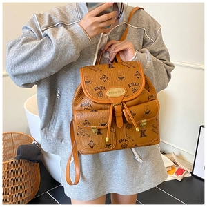Detail view of brown pebbled leather backpack with MK logo print and cartoon bear pattern