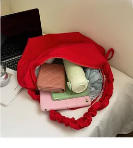 Macro view of the large capacity red tote bag showing interior storage space for tablets