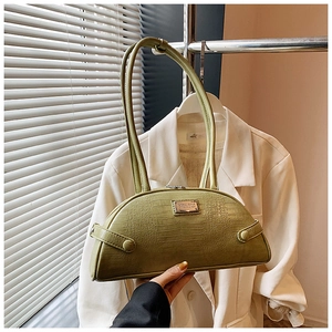 Close-up of grass green crocodile pattern handbag with silver logo plate detail