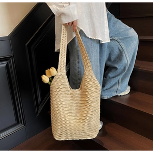 Detailed view of the woven straw tote bag texture with elegant tulip decorations