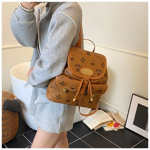 Detail of vintage brown backpack with teddy bear prints and drawstring flap closure