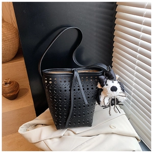Détail du sac seau noir ajouré avec cordon de serrage et charmant chien en peluche