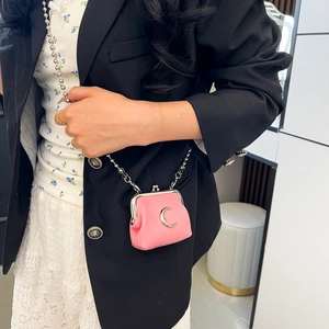 Detailed close-up of a pink mini kiss-lock bag with a silver moon and metal chain