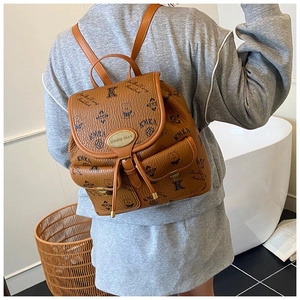 Brown bucket style backpack with cartoon bear patterns shown on a model's back