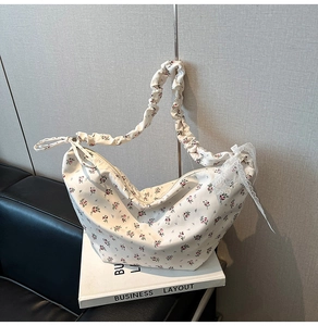 Close-up of floral handbag with pink patterns and a stylish ruffled cloud shoulder strap
