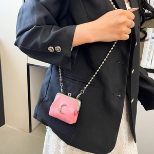 Close-up of pink mini kiss-lock bag with silver moon pendant and metal bead chain strap