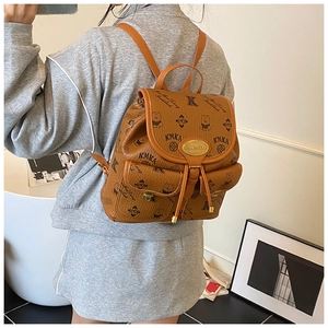 Detail of brown PU leather backpack with lychee texture and printed bear motifs