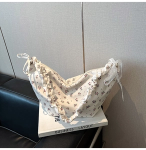Detail of floral Oxford fabric bag with ruffled edges and lace bow decoration