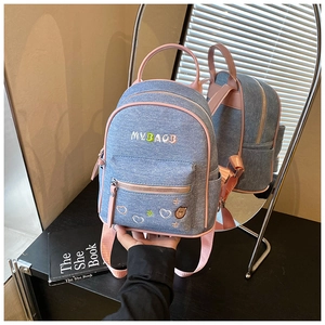 Detail of denim and pink leather backpack with MYBAGB letter and heart embroidery
