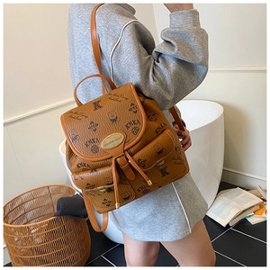 Brown PU leather backpack with bear prints and multiple pockets shown on model