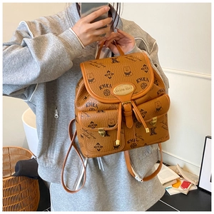 Detail of a brown leather bucket backpack featuring a bear print and multi-pocket design