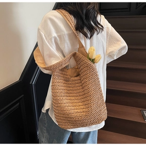 Detail of hand-woven straw shoulder bag with openwork mesh and rustic khaki texture