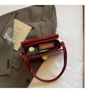 Top view of red patent leather handbag interior showing spacious capacity with gold lock