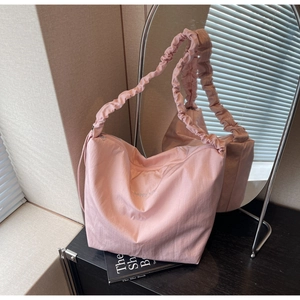 Detailed close-up of pink pleated canvas tote bag featuring embroidered Happy lettering