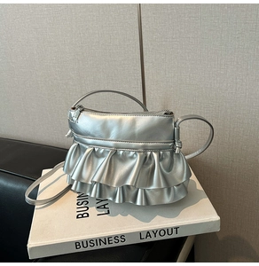 Detail of silver metallic handbag with ruffled pleated layers and fine stitching