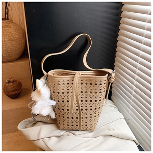 Détail du sac seau ajouré abricot avec motifs géométriques et pendentif en peluche
