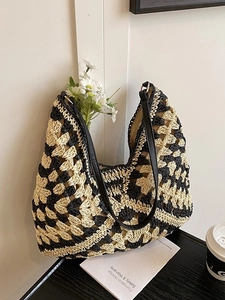 Handwoven crochet tote bag with geometric pattern and black leather straps in neutral setting