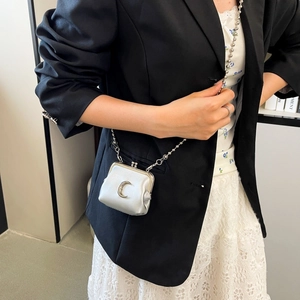 Close-up of mini silver metallic bag with crescent moon decor and bead chain strap