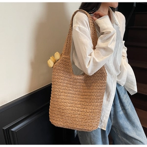 Detail of hand-woven straw shoulder bag with decorative yellow tulips for summer