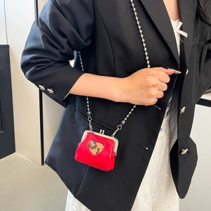 Detailed shot of a red heart-shaped mini crossbody bag with leopard print on a model