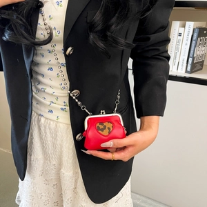 Close-up of a red heart-shaped mini kiss-lock bag with leopard print and silver ball chain