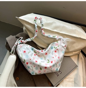 Detail of floral oxfords heart pattern on half-moon bag with ruffled strap and lace trim