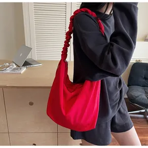 Detail of red canvas Hobo bag with pleated cloud shoulder strap in a home setting