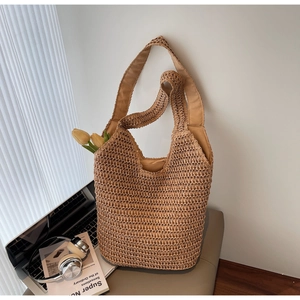 Close-up of large woven straw tote bag hanging on a chair with soft fabric lining