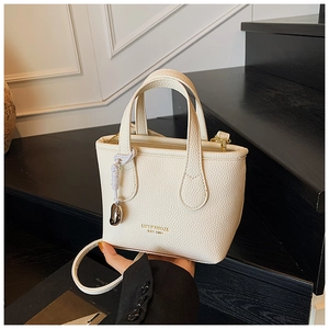 Dettaglio mini borsa a secchiello in pelle martellata bianco crema con logo oro