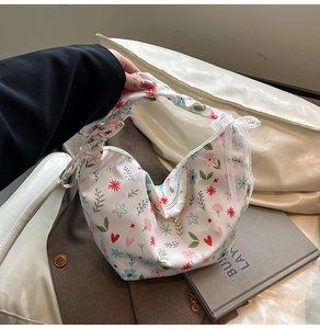 Detail of floral oxford fabric moon bag with lace bow and pleated handle design