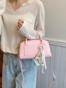 Pink lychee grain leather mini pillow bag with pearl charm and adjustable shoulder strap