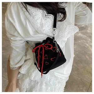 Détail du sac seau noir à motif cœurs rouges avec cordon et bandoulière chaîne