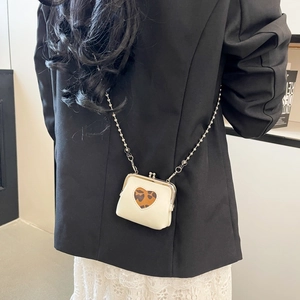 Close-up of mini cream crossbody bag with leopard print heart and silver ball chain