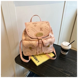 Detailed macro view of pink vintage mini bucket bag with bear print and golden logo plate