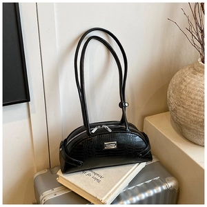 Close-up of black crocodile pattern leather bag with silver buckle and dual zipper