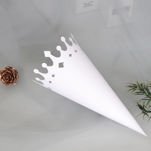 Close-up of white paper petal cone with elegant crown-shaped hollow-out lace design