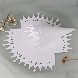 Detail of laser-cut wedding petal cones featuring white crown hollow lace patterns