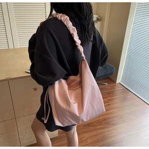 Detail of pink canvas tote bag showing pleated shoulder strap and large capacity design