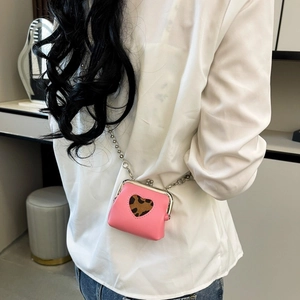Pink heart-shaped leopard print mini chain bag shown on a model in a casual setting