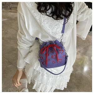 Vue détaillée du sac seau en velours côtelé violet avec broderie cœur rouge et cordon serrage
